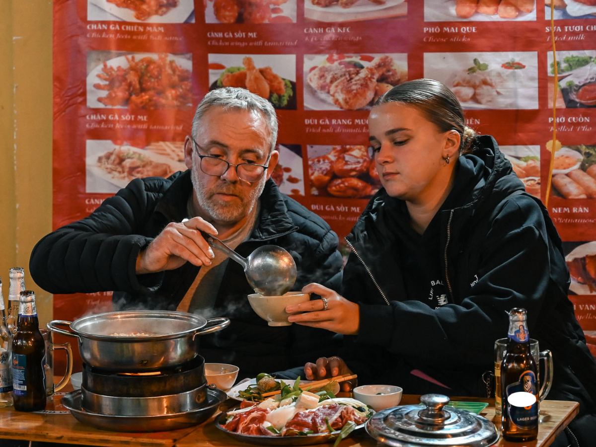 Du khách nước ngoài thưởng thức các món ăn đêm hấp dẫn.