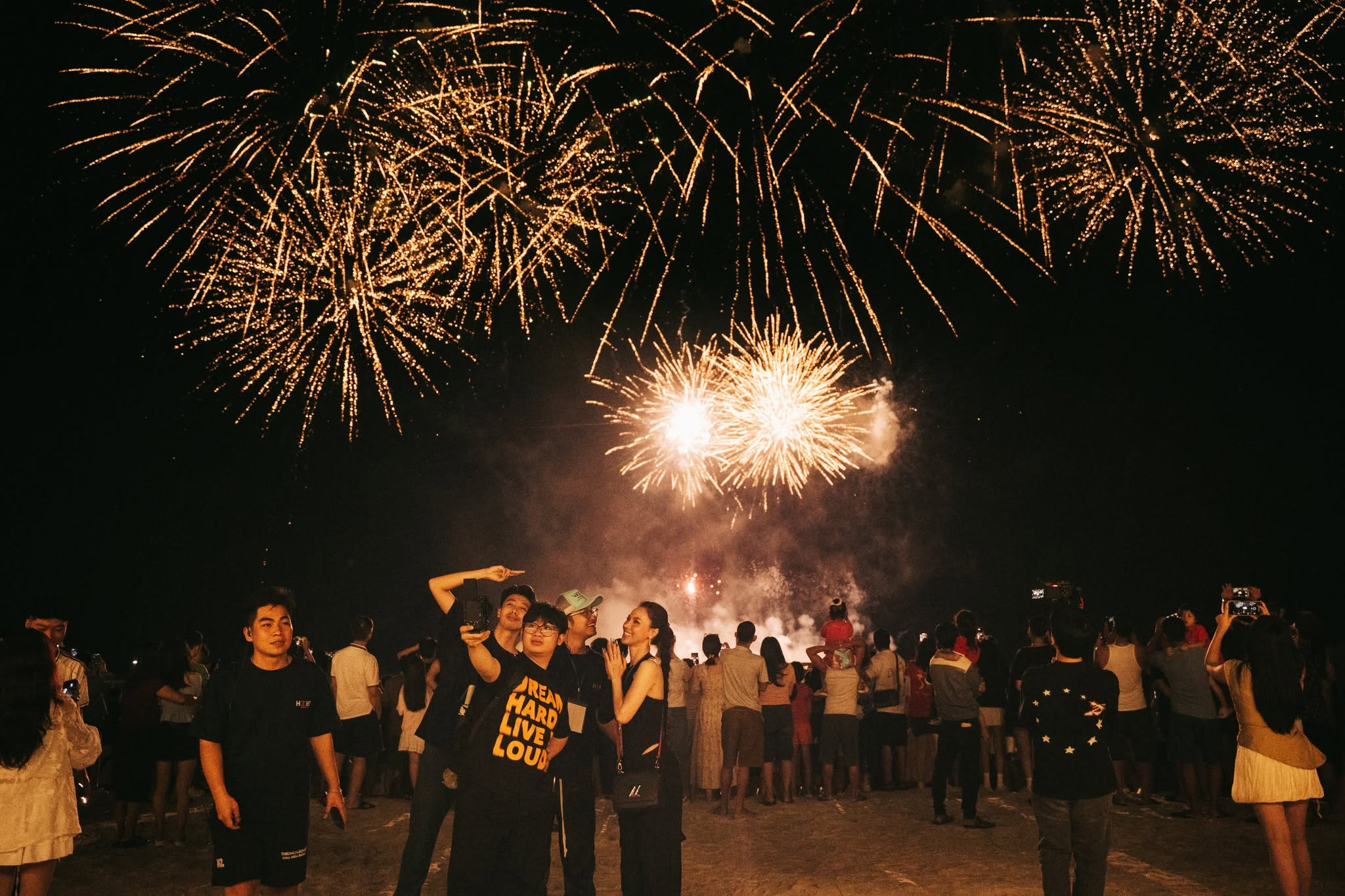 Du khách chiêm ngưỡng pháo hoa trong không gian lễ hội náo nhiệt bên vịnh.