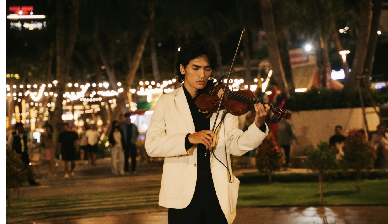 Nghệ sĩ violin biểu diễn trong không gian biển đêm đầy cảm xúc.
