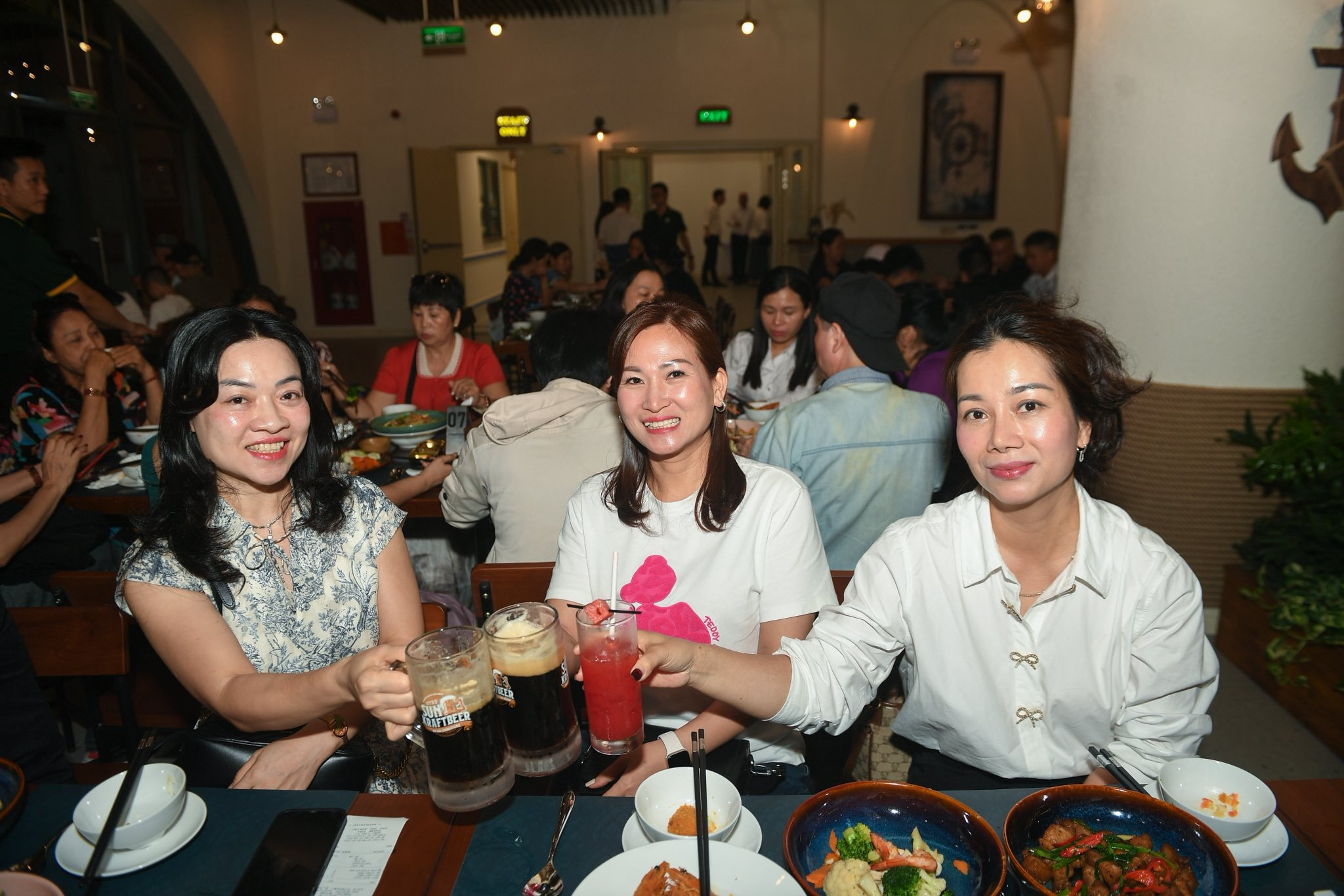 Du khách nâng ly Sun KraftBeer giữa không gian biển đêm sôi động.