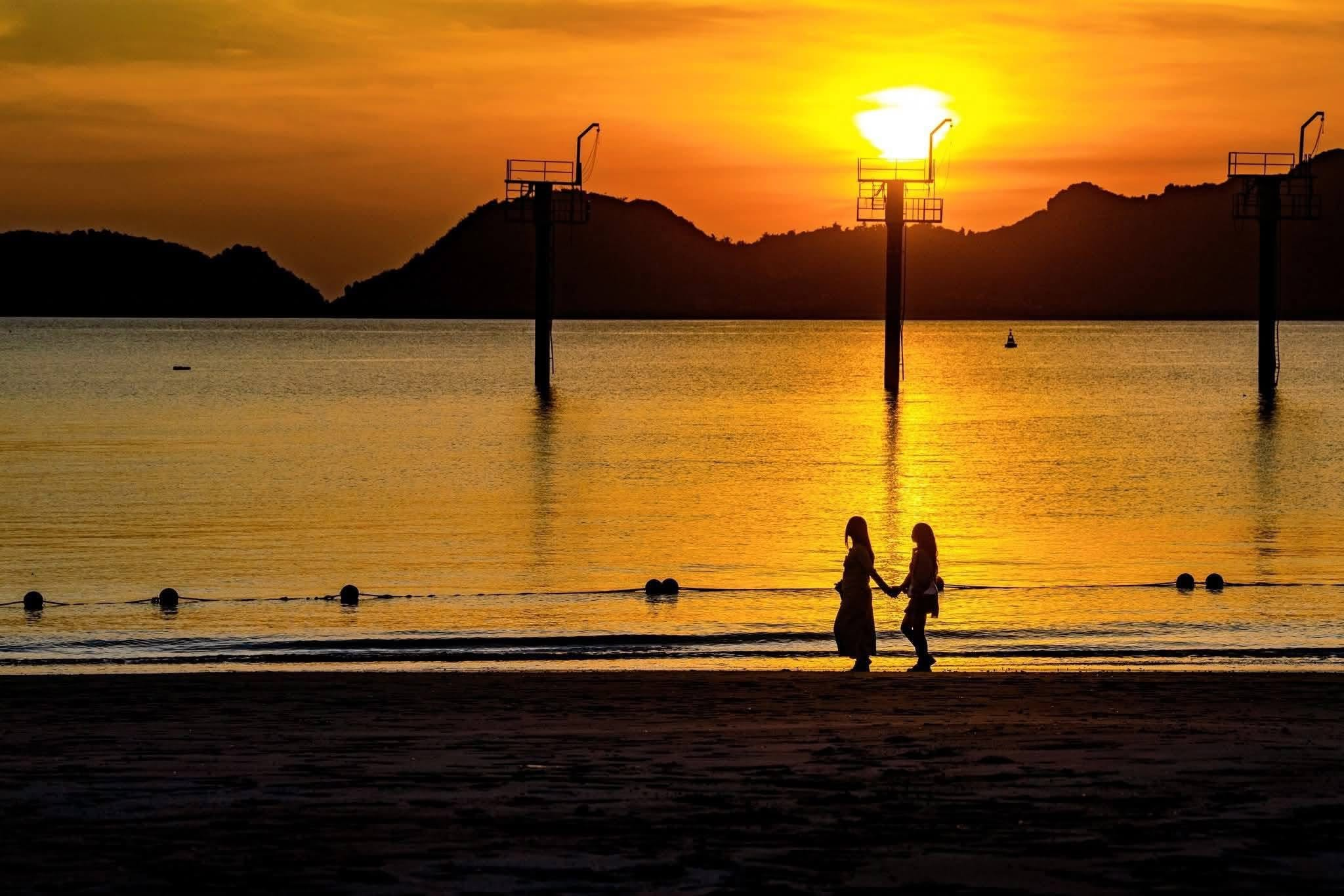 The sun gradually disappears behind the limestone islands, creating an evocative scene on Cat Ba