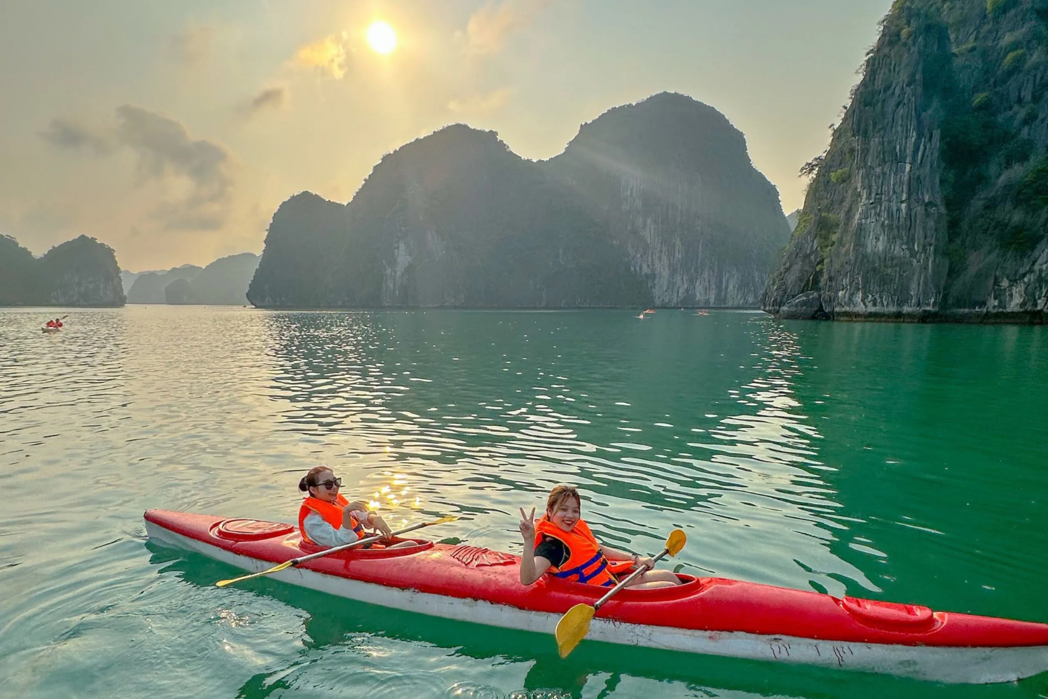 Hoàng hôn phủ vàng mặt nước giữa Sunset bathes the waters between hundreds of limestone islands in Lan Ha Baytrăm đảo đá trên vịnh Lan Hạ