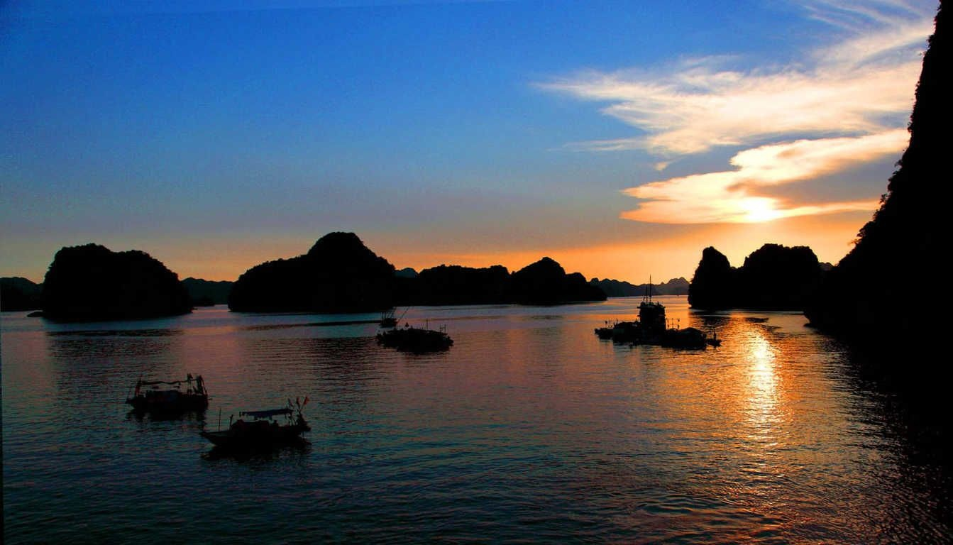 Sunrise bathes the waters of Cat Ba in golden light on clear summer mornings