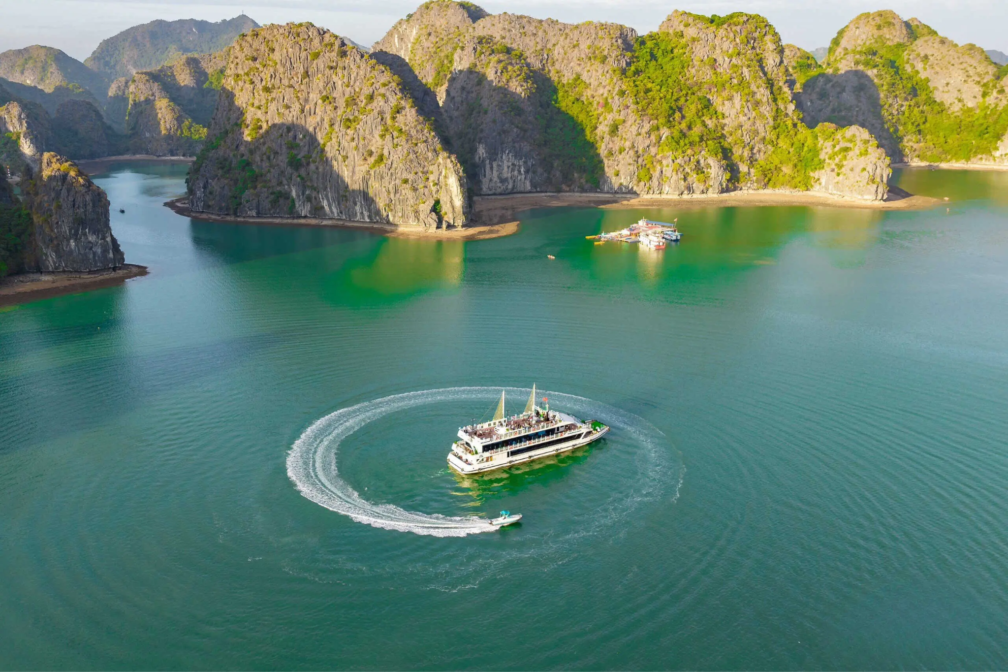 Du thuyền đưa du khách đi giữa những đảo đá phủ xanh và mặt nước trong veo của vịnh Lan Hạ