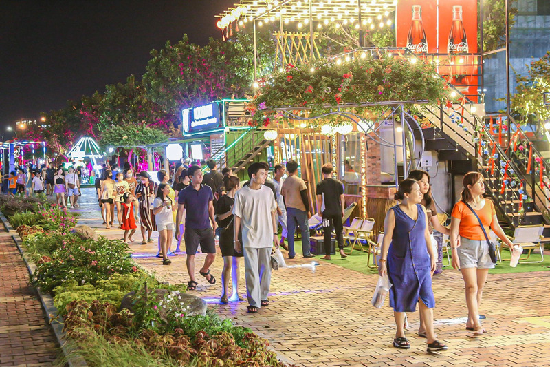 Visitors enjoying a relaxed evening stroll along Bach Dang Walking Street by the Han River