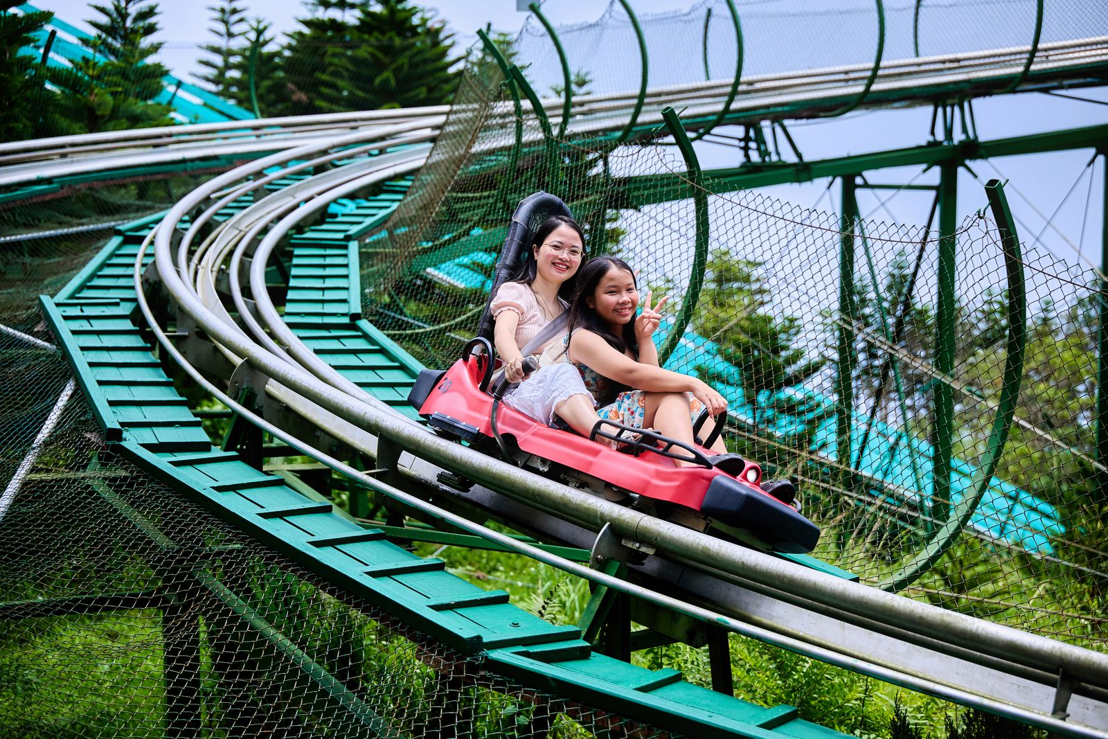Du khách trải nghiệm máng trượt Alpine Coaster giữa khung cảnh núi rừng xanh mát. (Nguồn: Sưu tầm)