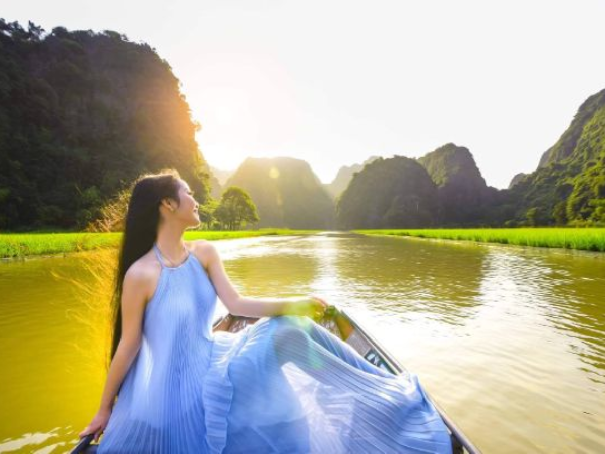 Mặc váy dài check in khi chèo thuyền Tam Cốc tạo nên khung hình đẹp lay động lòng người.