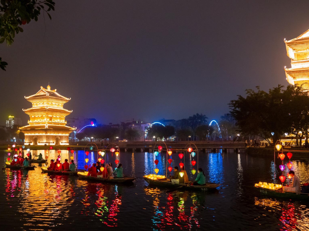 Phố cổ Hoa Lư về đêm lung linh với những dãy đèn lồng, thuyền hoa và công trình kiến trúc truyền thống bên mặt nước. (Nguồn: Sưu tầm)