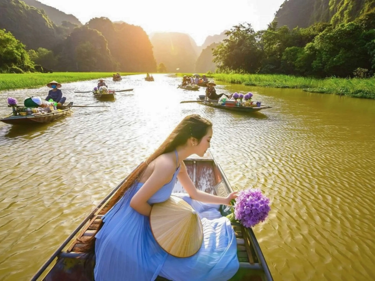 Ngồi thuyền check-in với dòng sông Ngô Đồng và cánh đồng lúa chạy dọc hai bên bờ. (Nguồn: Sưu tầm)