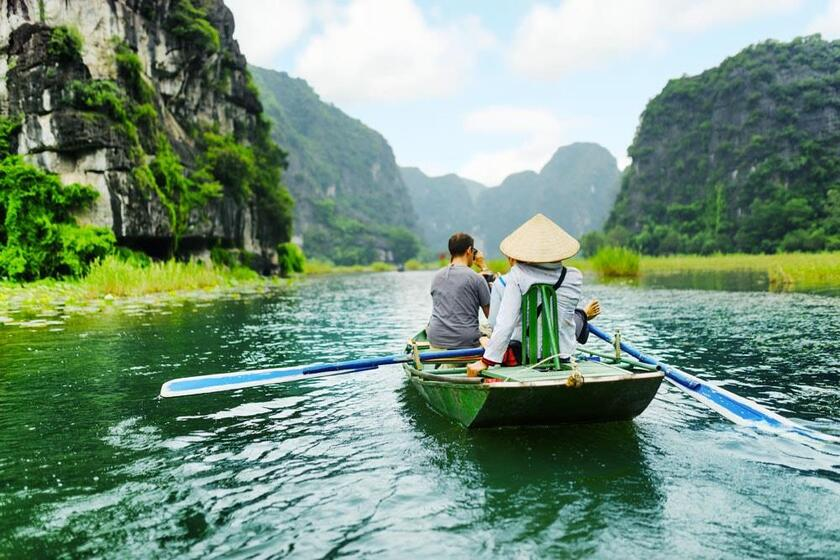 Du khách đi thuyền tham quan và ngắm cảnh Ninh Bình trên sông Ngô Đồng.