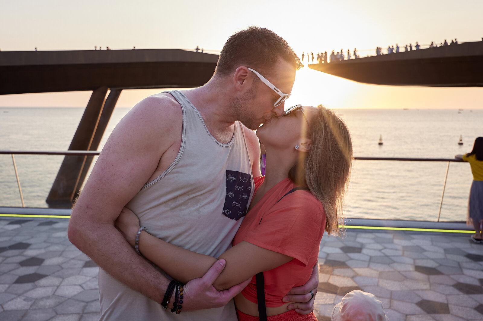Tourists watch the sunset together at Kiss Bridge