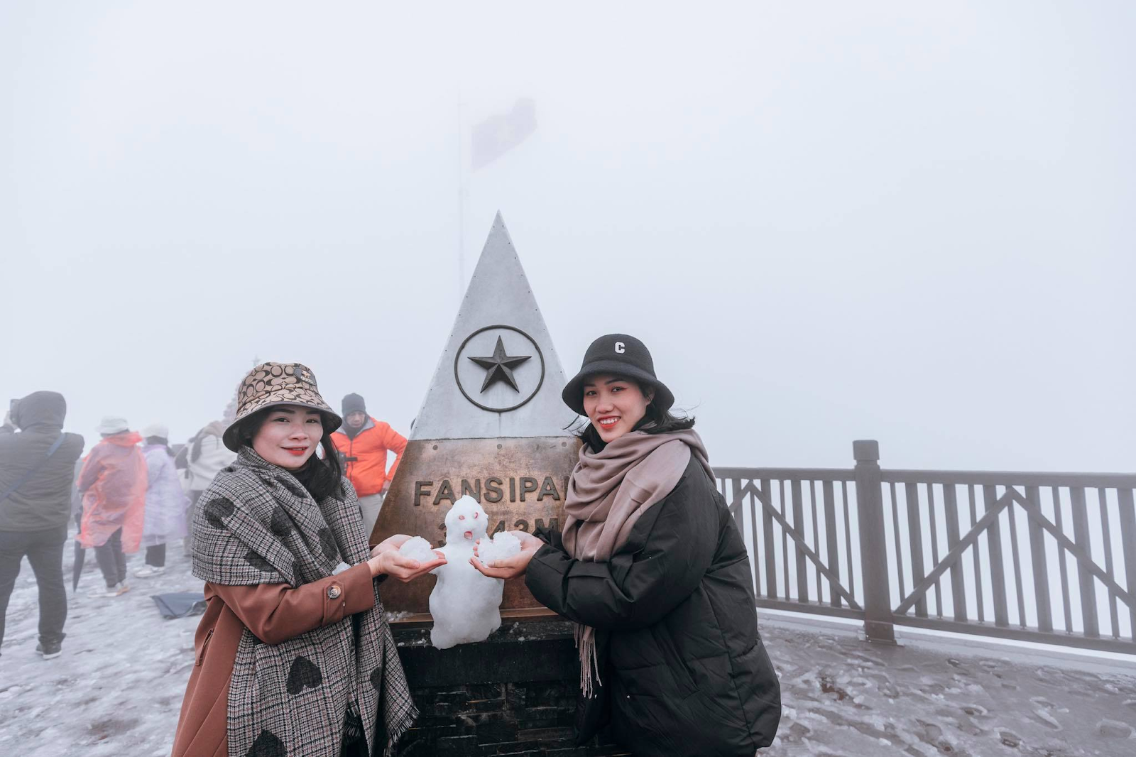 Visitors enjoy making snowman figures atop Fansipan