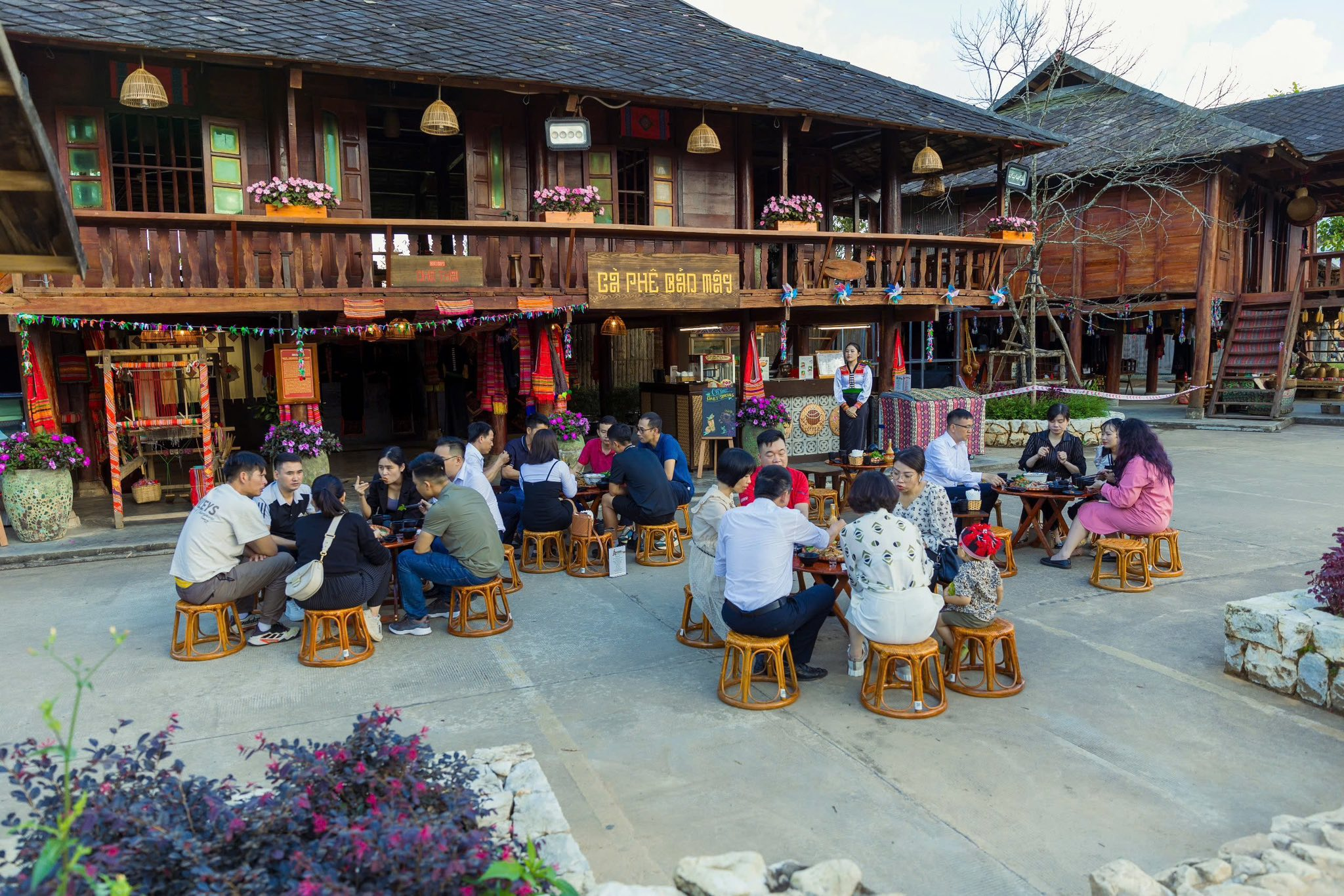Travelers enjoy drinks in a traditional highland stilt-house setting