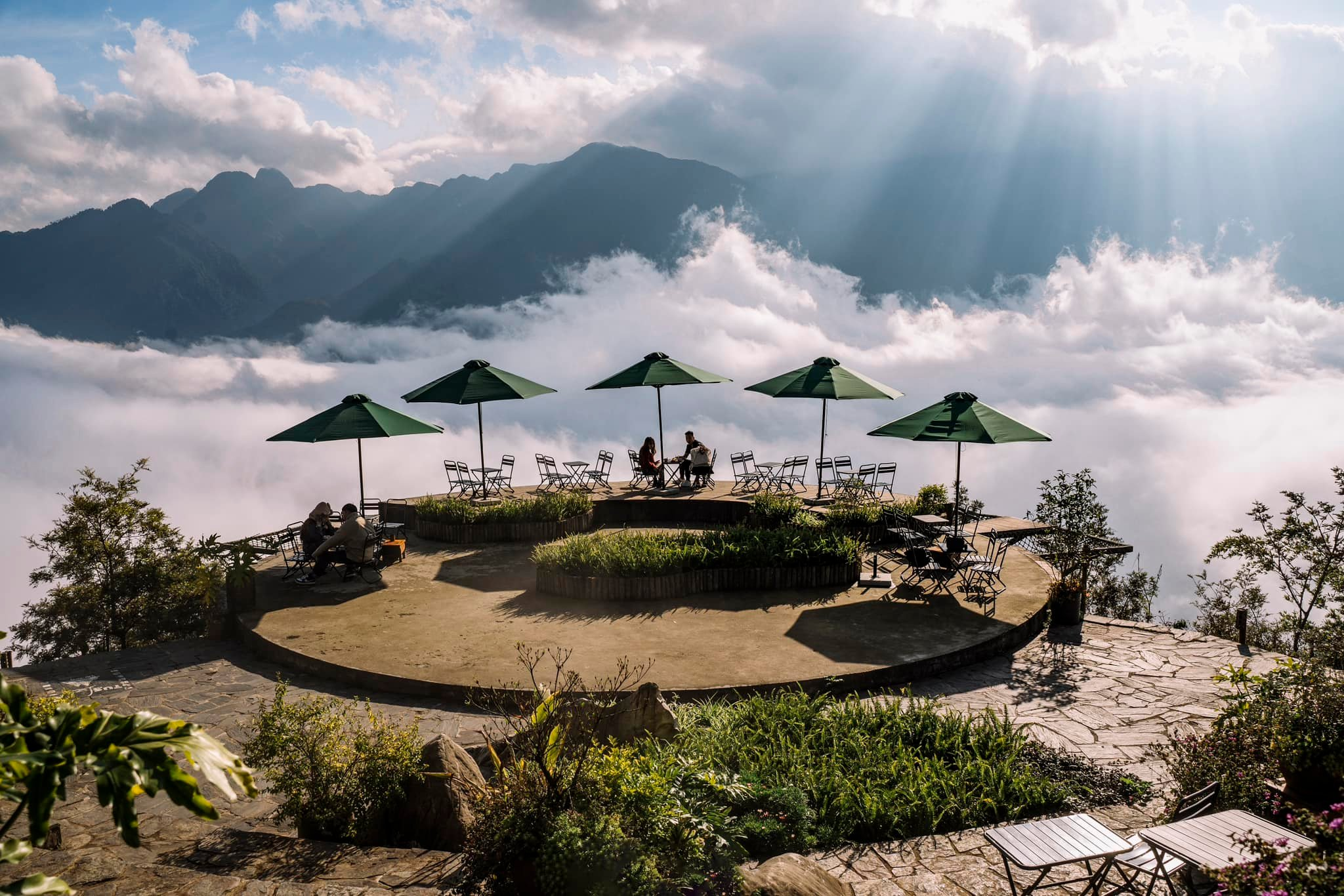 A sea of clouds surrounds cliffside cafe seating at 1,600 meters