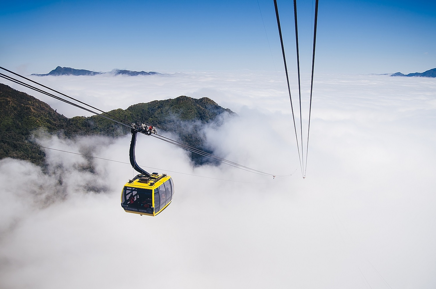 The Fansipan cable car takes visitors across layers of white clouds amidst the Hoang Lien Son mountain range.