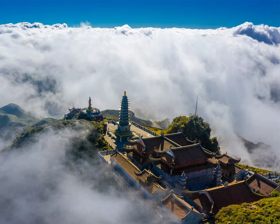 Fluffy white clouds drift over the summit of Fansipan