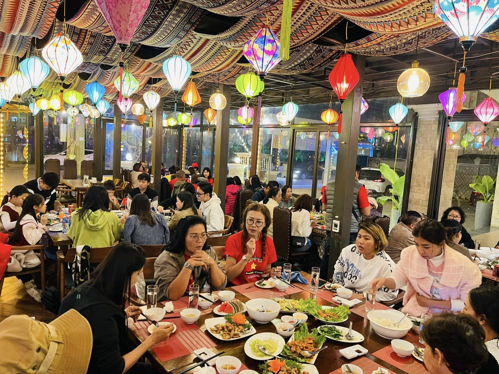 Không gian nhà hàng được trang trí bằng đèn lồng và nội thất gỗ mộc.