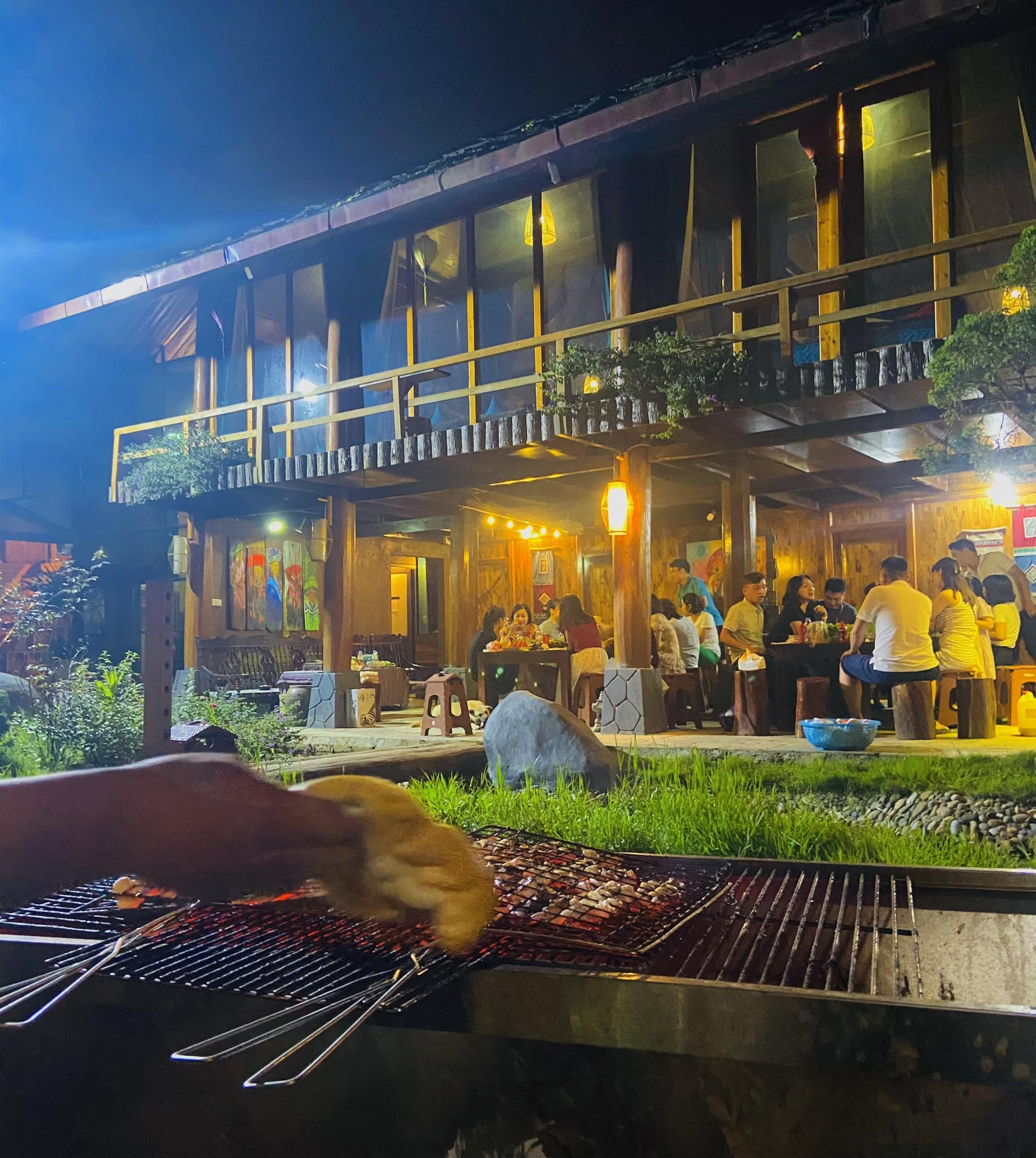 Du khách cùng người dân bản địa thưởng thức bữa tối trong không gian ấm cúng giữa núi rừng Tây Bắc.