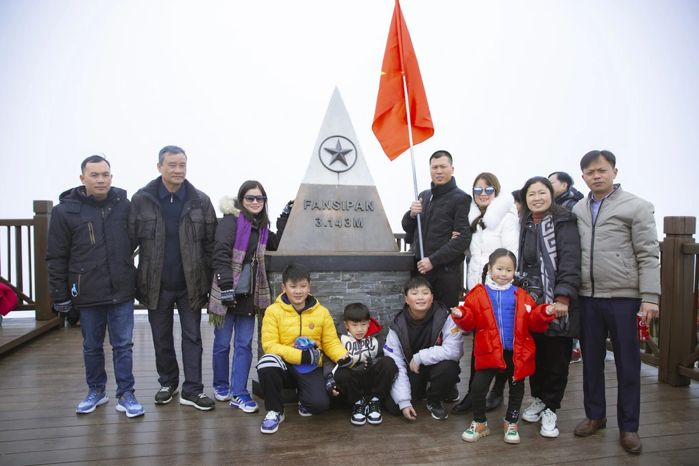 旅客在番西邦山山頂3,143公尺地標前打卡留念