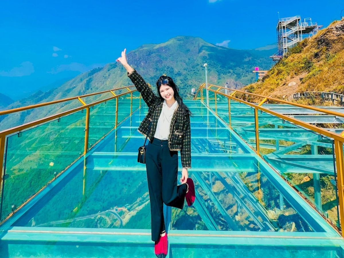 Tourists stroll across the Rong May Glass Bridge
