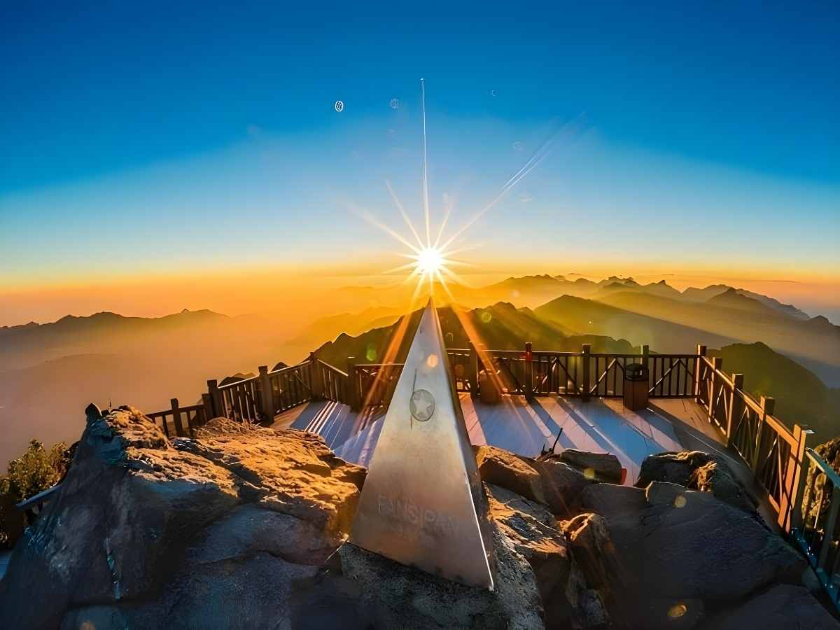 Du khách đứng trên đỉnh Fansipan ngắm bình minh giữa biển mây và dãy núi hùng vĩ Tây Bắc. (Nguồn: Sưu tầm)