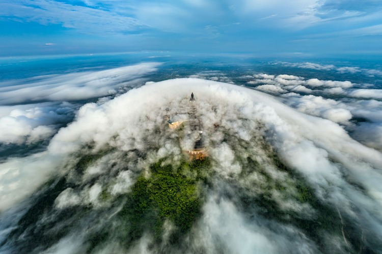 Rolling clouds transform Ba Den Mountain into an island in the sky