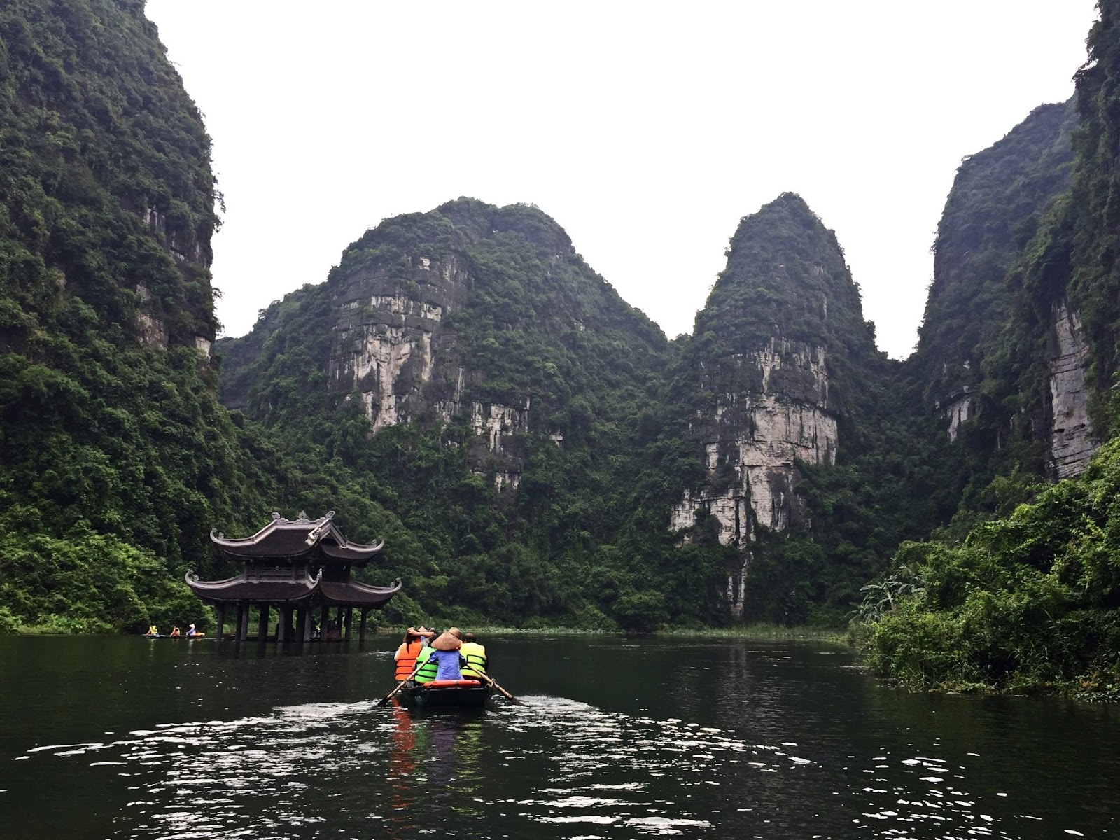 Take a boat tour through the caves and within mountains at Ninh Binh