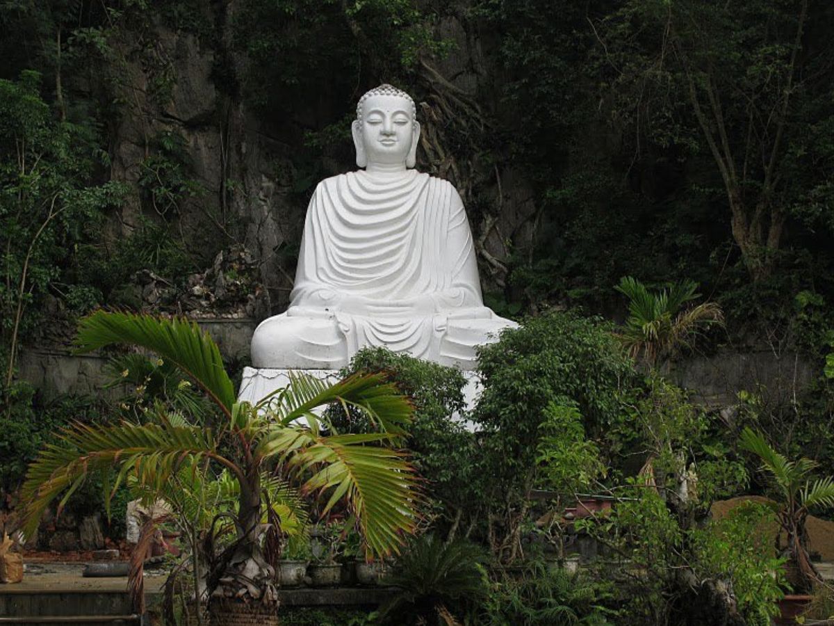 A Buddha statue nestled in the forest, resting its back against the mountain (Photo: Collected)