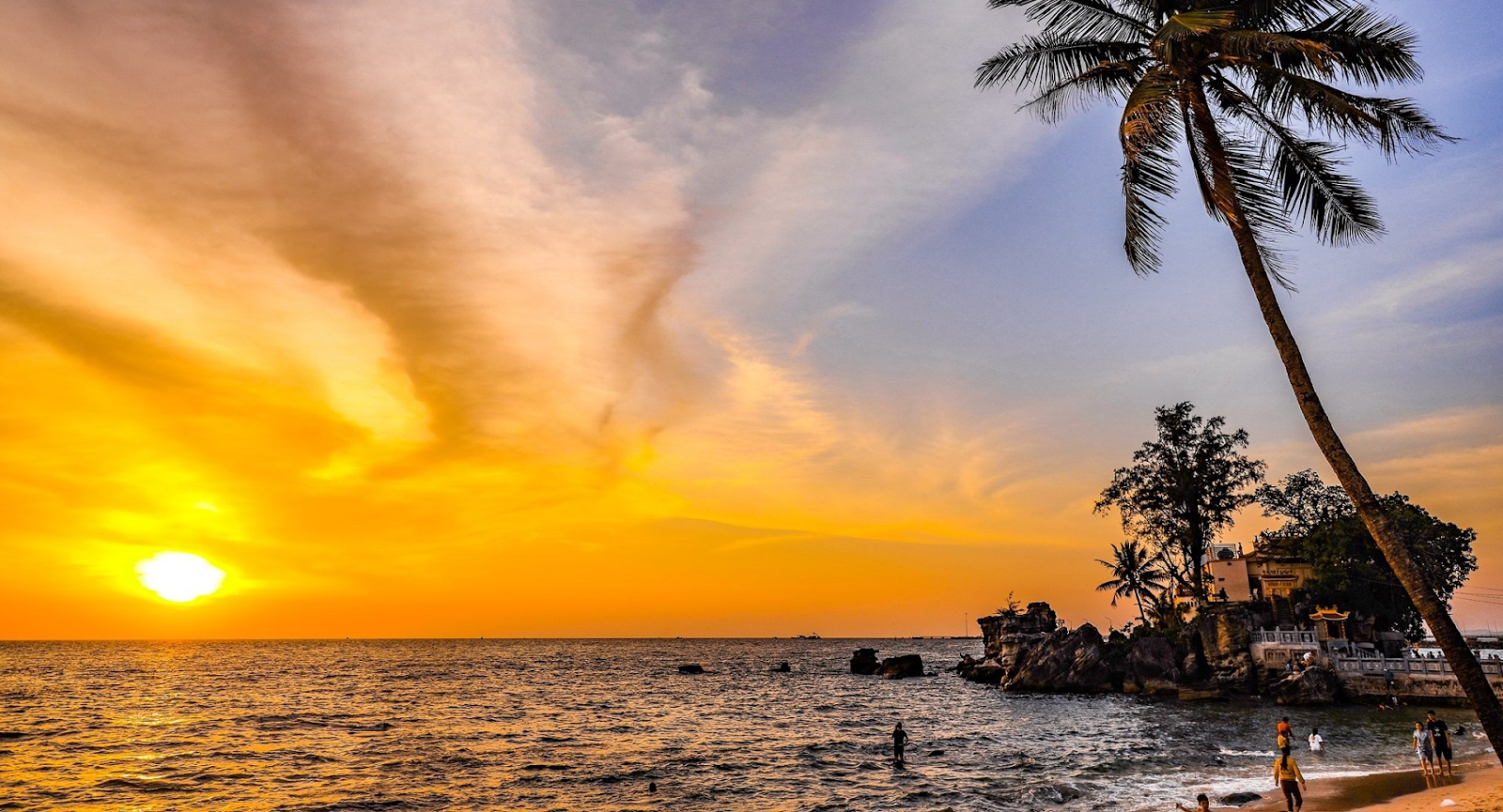 Dinh Cau beach is the best spot for a wide landscape photo showing the temple on the rocks against the sunset sky.