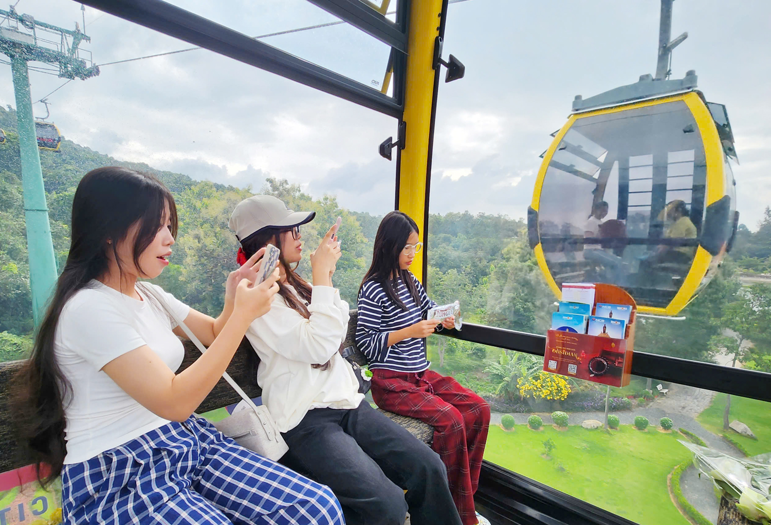 Tourists enjoy the experience of riding the Ba Den cable car