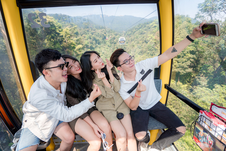 Tourists excitedly experience and take photos on the Ba Den cable car