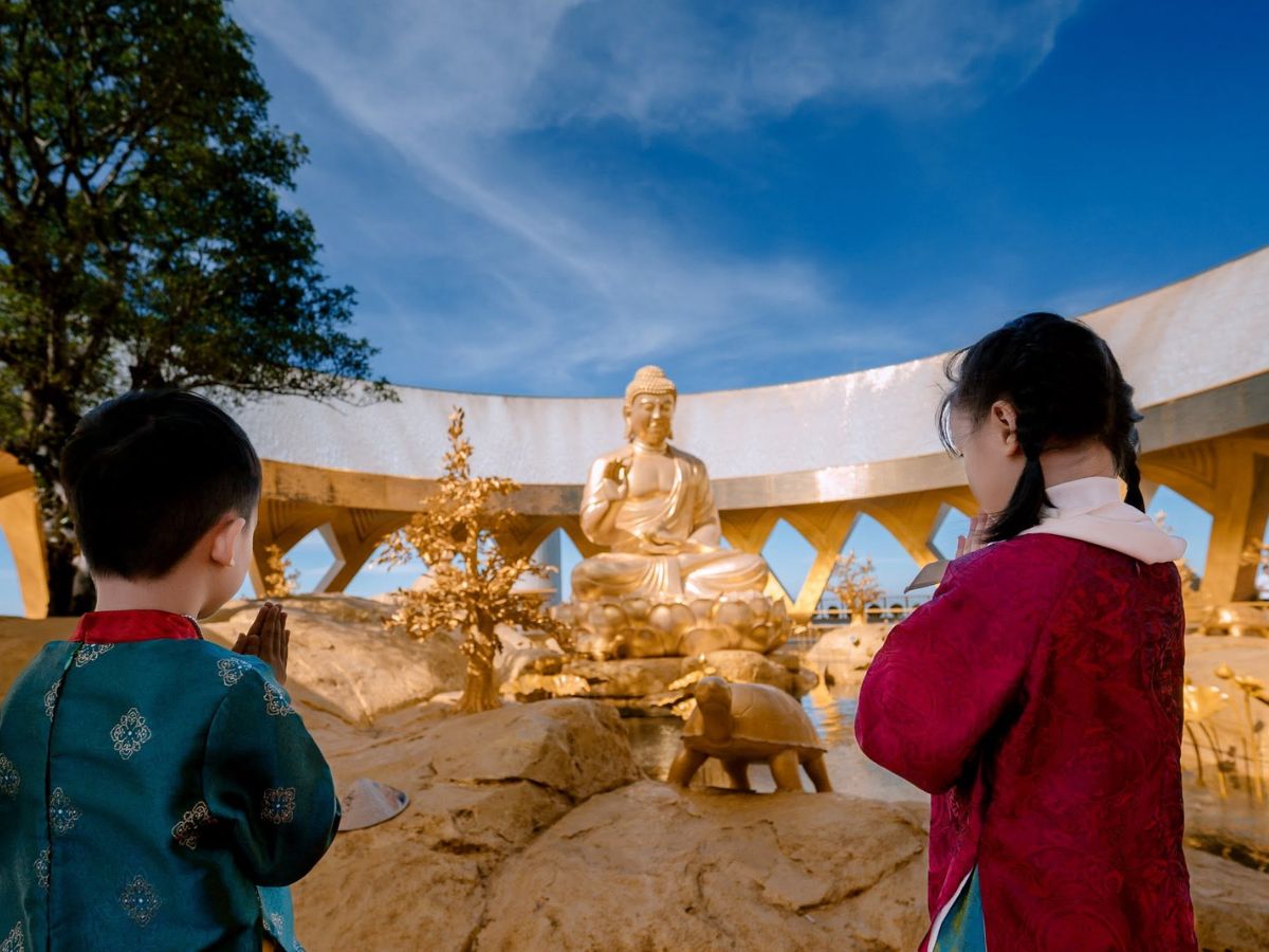 Trẻ em chắp tay chiêm bái tượng Phật trong không gian đỉnh Núi Bà Đen.