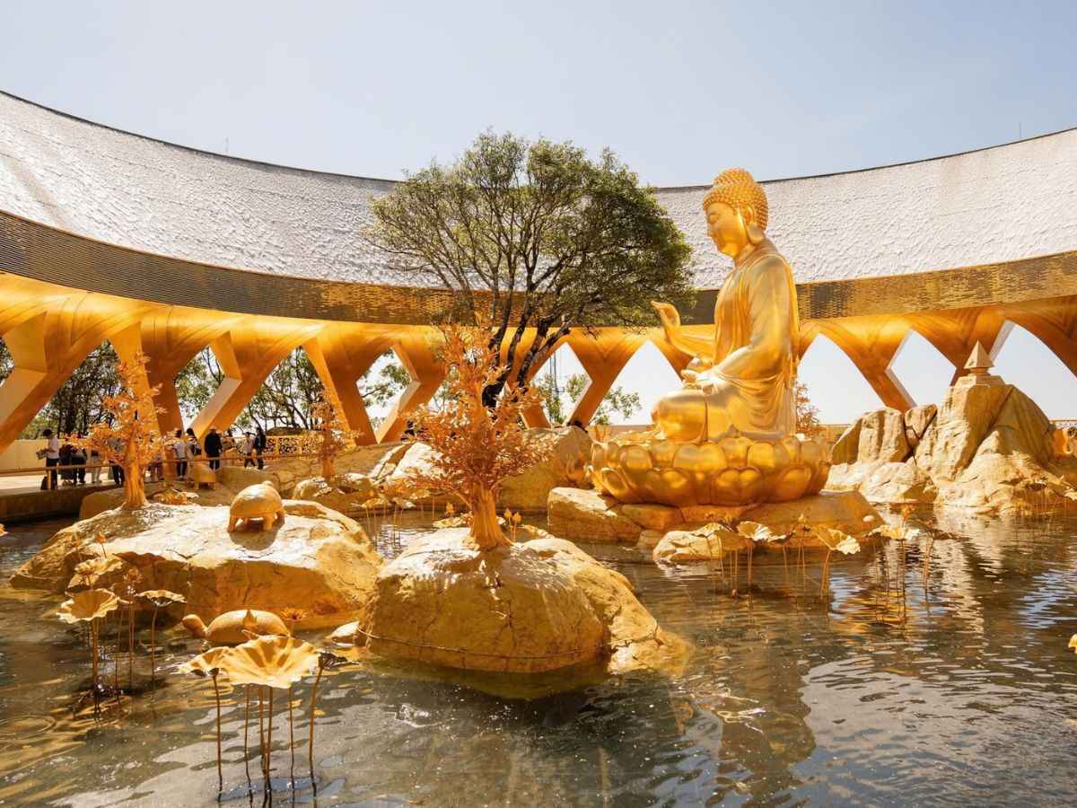 Tượng Phật Câu Na Hàm Mâu Ni giữa hồ sen vàng tại Vườn Ưu Đàm.