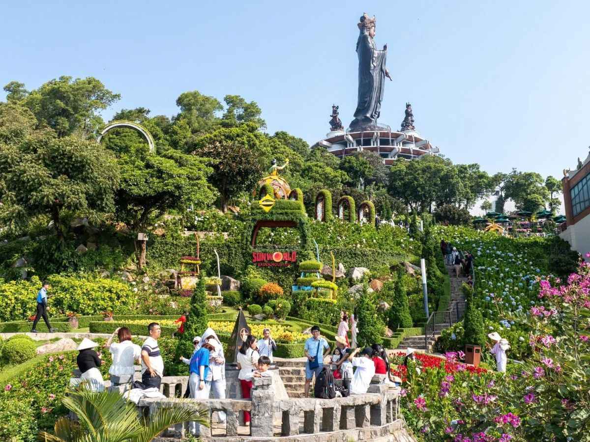 Du khách tham quan vườn hoa dưới chân tượng Phật Bà Tây Bổ Đà Sơn.