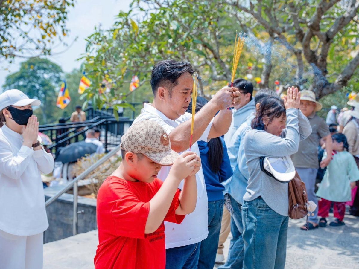 Du khách dâng hương, cầu an trong hành trình hành hương lễ Phật.