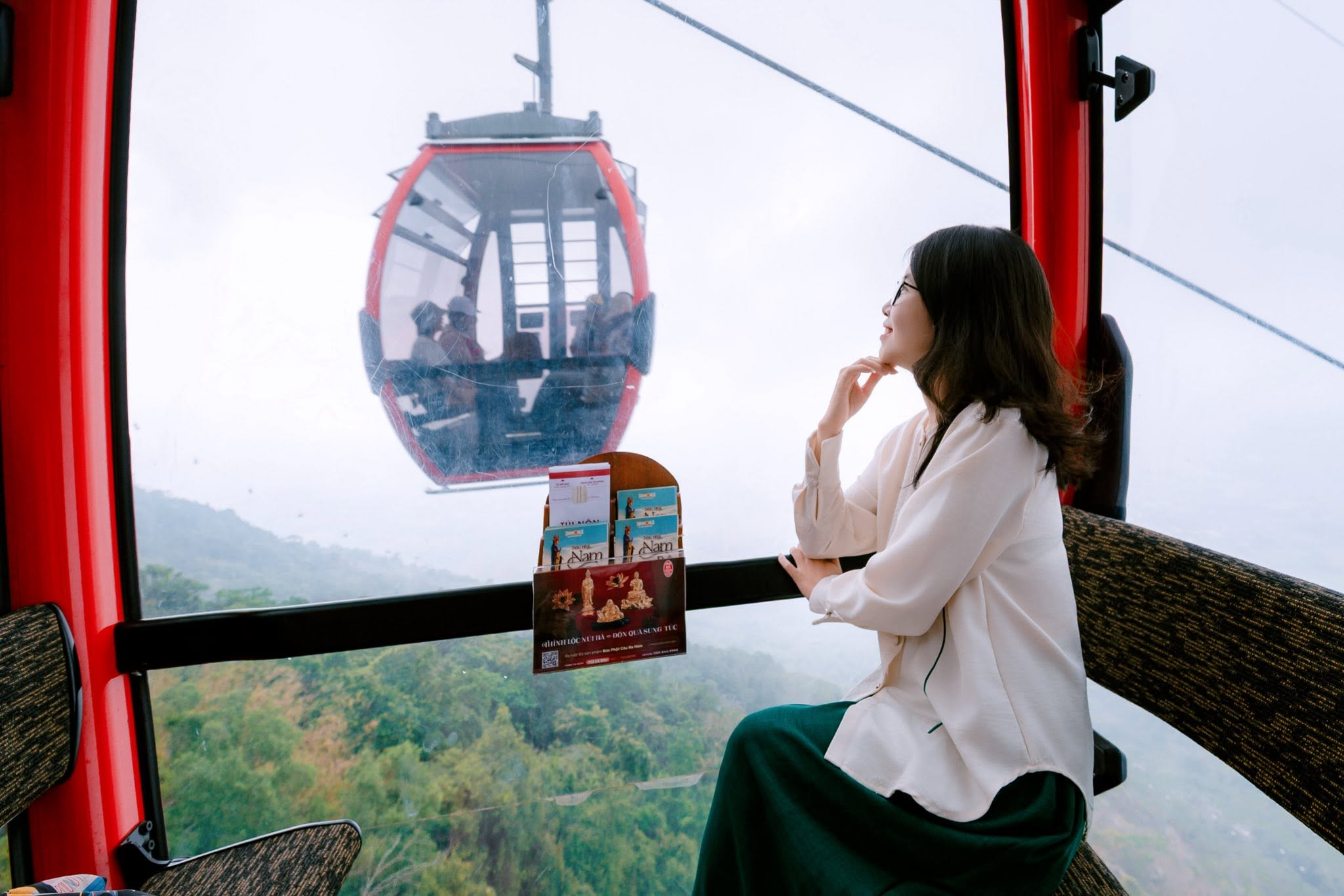 Tourists enjoy the experience of riding the cable car up Mount Ba Den.