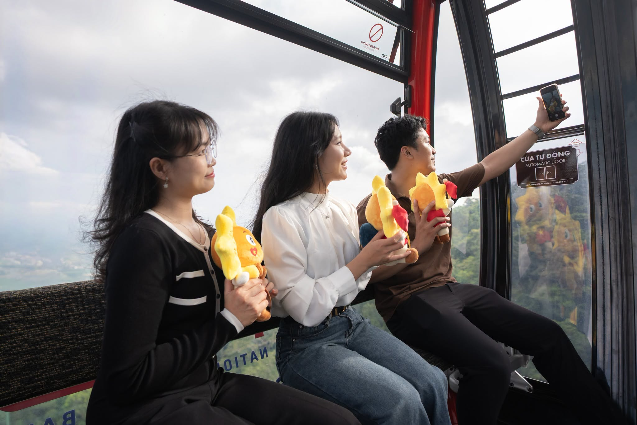Tourists experience the cable car ride on Ba Den Mountain