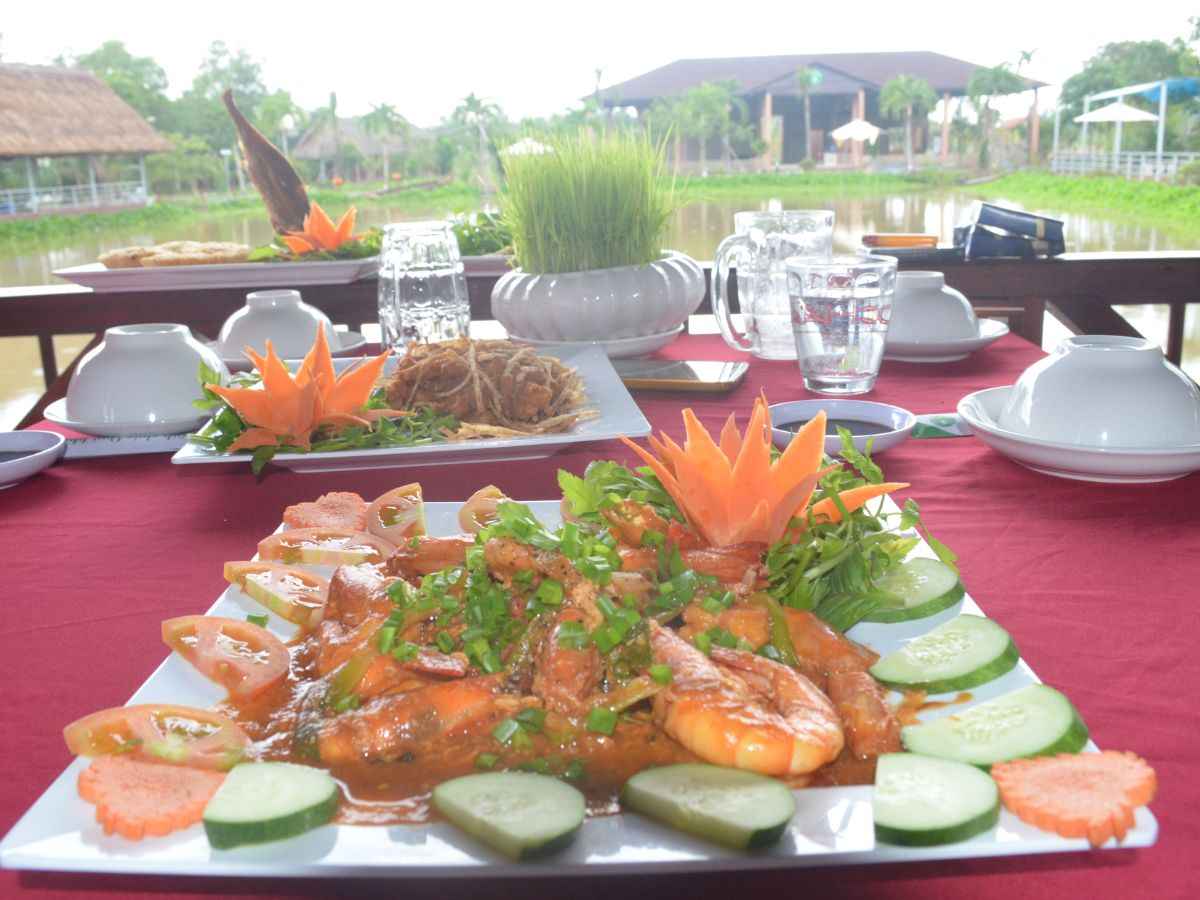 Món ăn hấp dẫn tại Làng Ẩm Thực Cây Trường với view hồ cực mát mẻ.