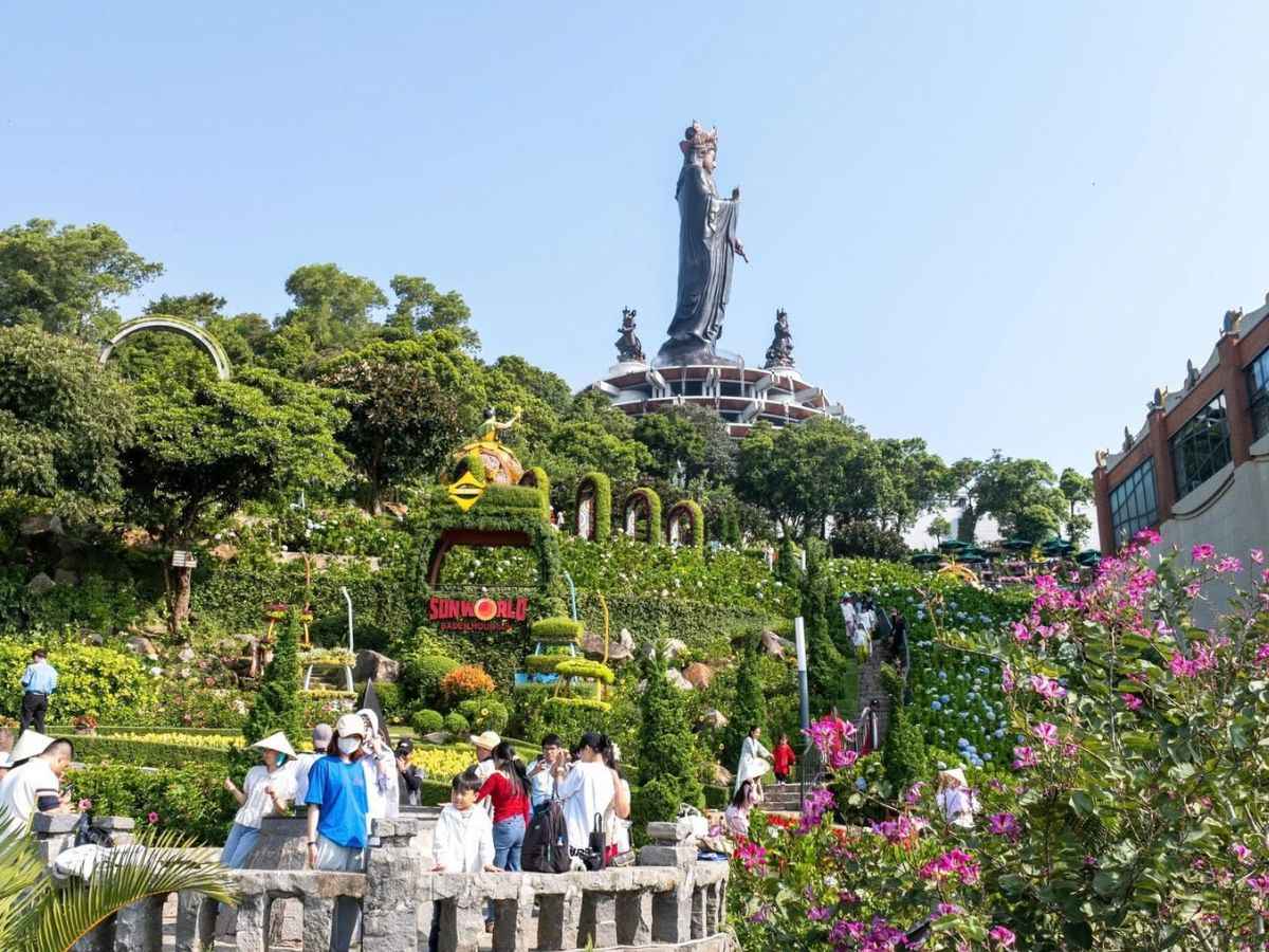 Du khách vãn cảnh giữa vườn hoa dưới tượng Phật Bà Tây Bổ Đà Sơn