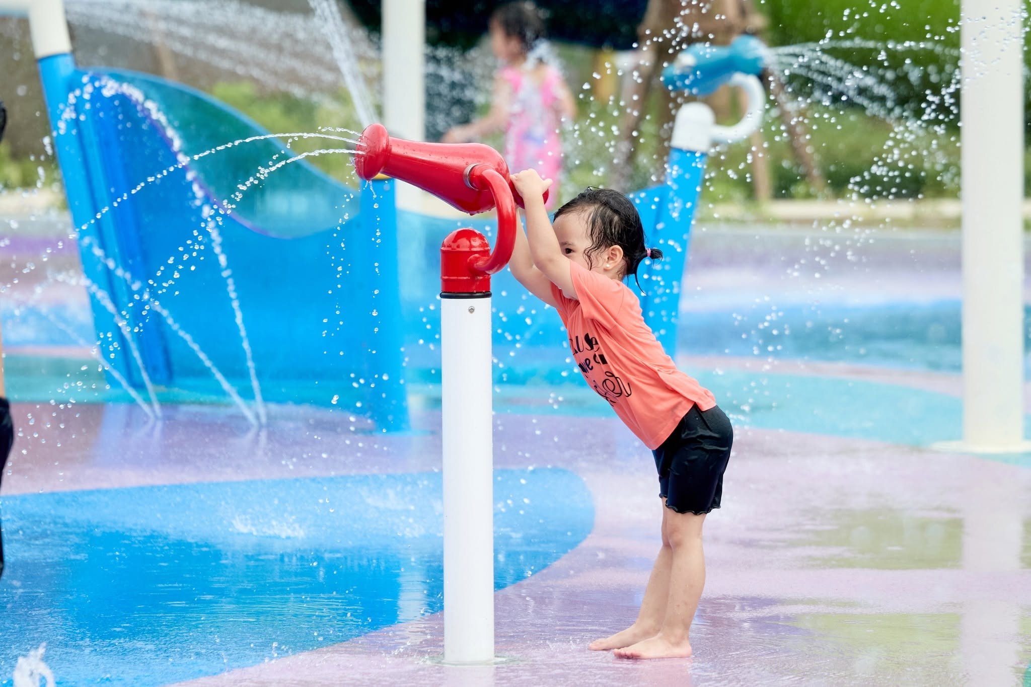 Trẻ em vui chơi tại hồ nước nông với hệ thống cầu trượt mini và trò chơi tương tác an toàn