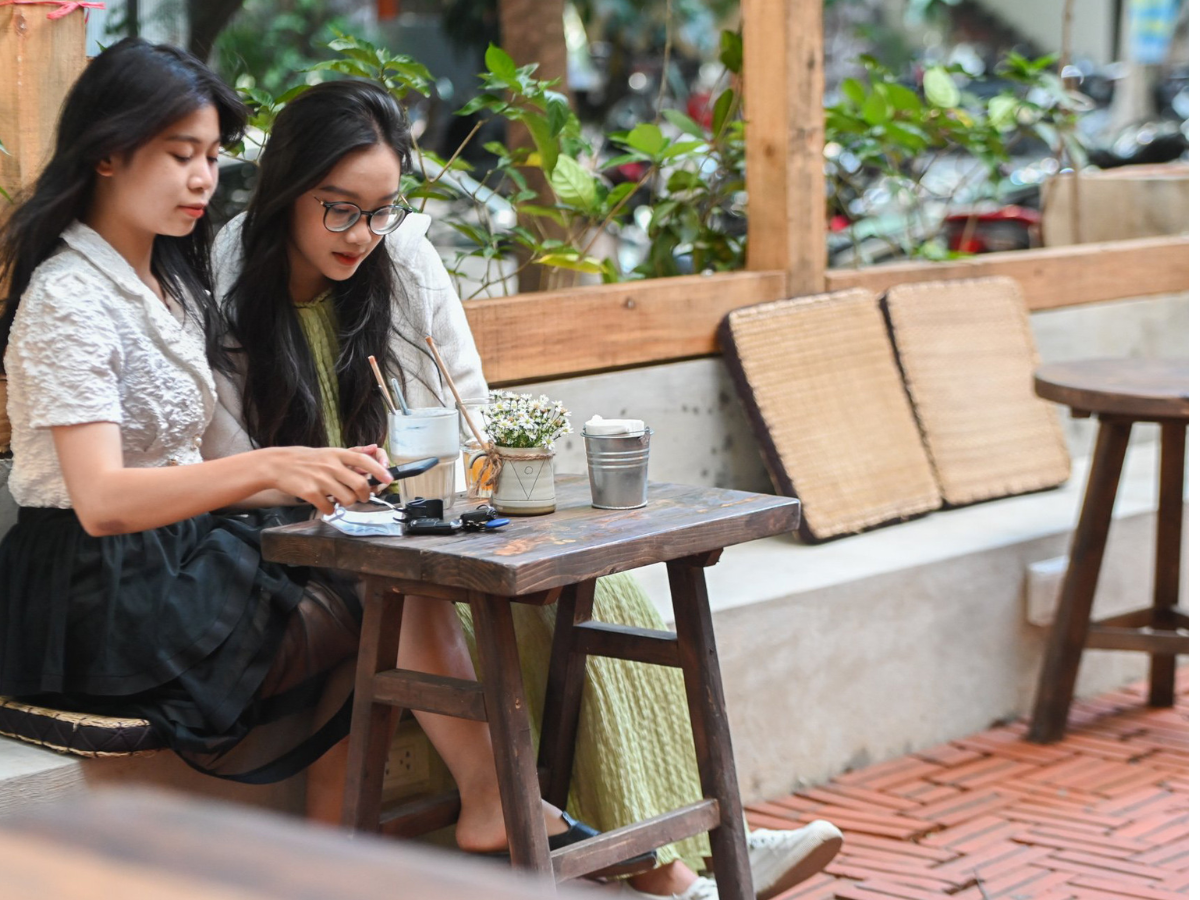 Hai du khách cùng kiểm tra thông tin đặt vé trên điện thoại, giúp chuyến đi được chuẩn bị kỹ lưỡng hơn.
