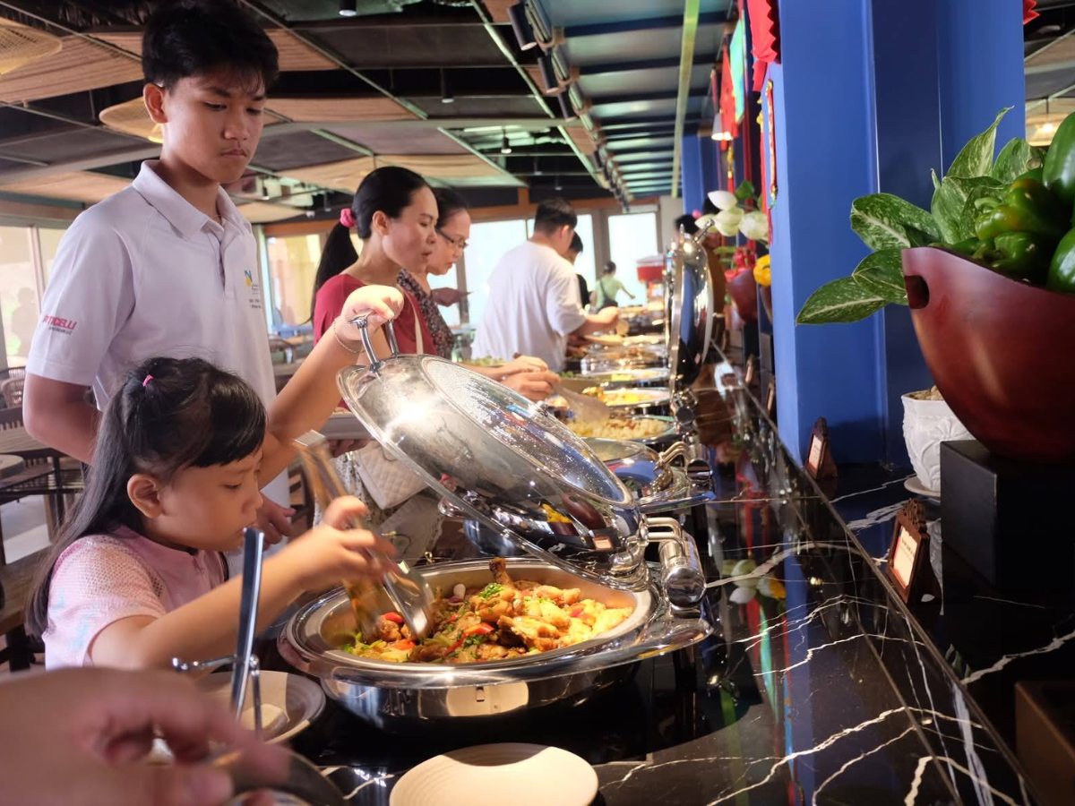 Du khách di chuyển đến quầy buffet để lựa chọn món ăn và bắt đầu trải nghiệm ẩm thực tại Sun World Vung Tau