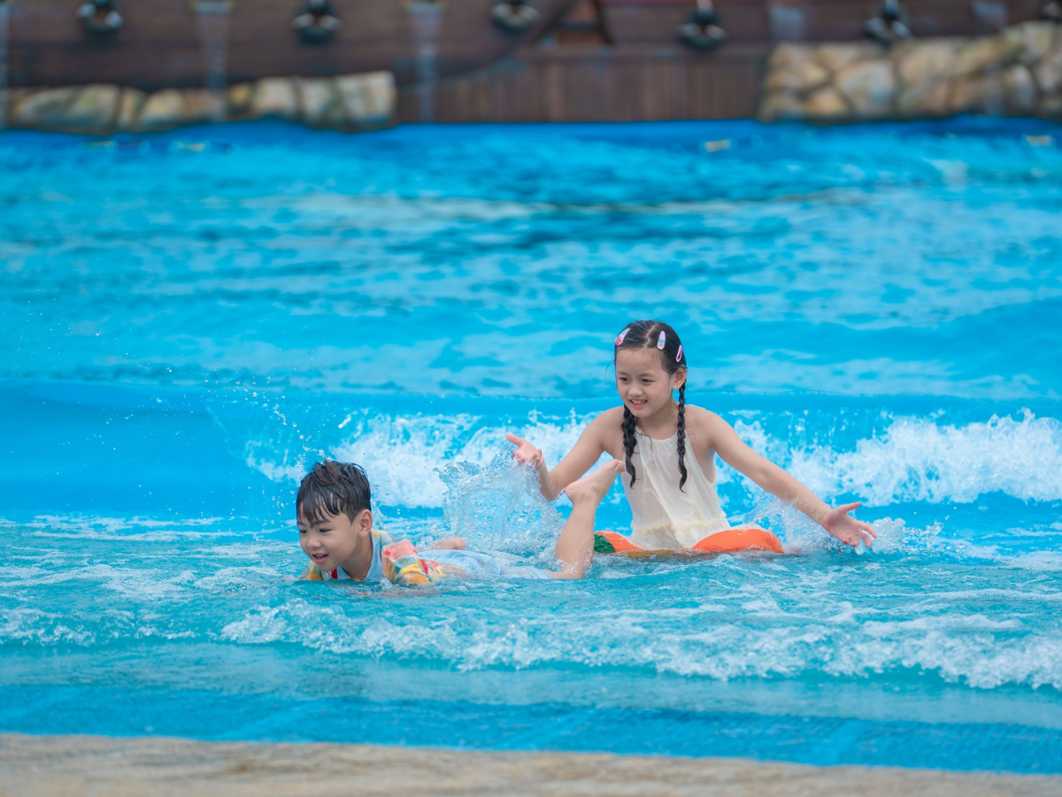 Khoảnh khắc vui chơi rộn ràng của hai bé giữa làn nước mát, tràn đầy tiếng cười và năng lượng tuổi thơ.